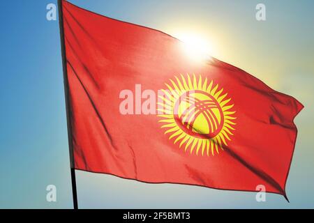 Kirgisistan Flagge winkt auf dem Wind vor der Sonne Stockfoto