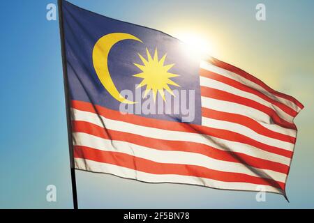 Malaysia Flagge winkt auf dem Wind vor der Sonne Stockfoto