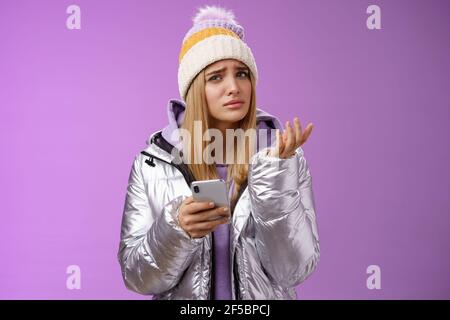 Befragt kompliziert niedlich blonde Freundin erhalten seltsame Nachricht aussehen verwirrt Verwirrt Heben Hand zuckend Lift Augenbraue kann nicht verstehen Stockfoto