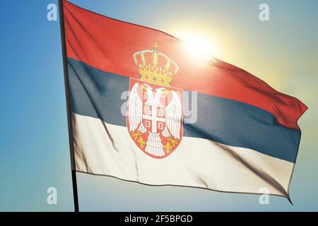 Serbien Flagge winkt auf dem Wind vor der Sonne Stockfoto