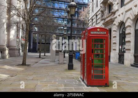 Typische Londoner Telefonzellen umgeben von einer alten Londoner Architektur, Royal Exchange, Cornhill Stockfoto