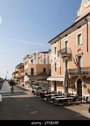 Bardolino, Italien. 25th, März 2021. Blick entlang der Piazza Giacomo Matteotti Hauptstraße in Bardolino Stadt am Mittag, am Gardasee, noch-ihnen Italien.- (hinter Gardasee). Bardolino ist berühmt für die Kultur des gleichnamigen Rotweins, der auf der ganzen Welt bekannt ist und ein historisches Erbe hat, von dem die antiken Mauern, die zahlreichen Kirchen und Villen der venezianischen Zeit zeugen. Jedes Jahr kommen tausend Touristen im Frühling an, heute am fünften Tag des Frühlings. Seine Straßen sind leer, während der dritten Welle der Covid-19 Epidemie. Der neue Lockdown startete vor 17 Tagen (8. märz) in Italien. Quelle: ALEJANDRO SA Stockfoto