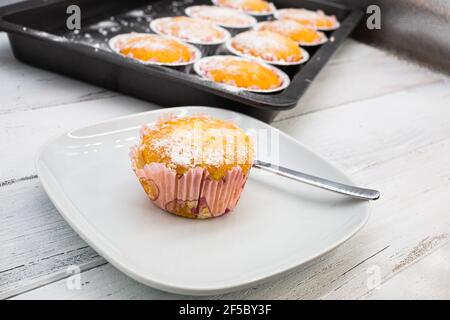Set mit verschiedenen frisch gebackenen VanilleMuffins auf weißem rustikalem Holztisch, Seitenansicht Stockfoto