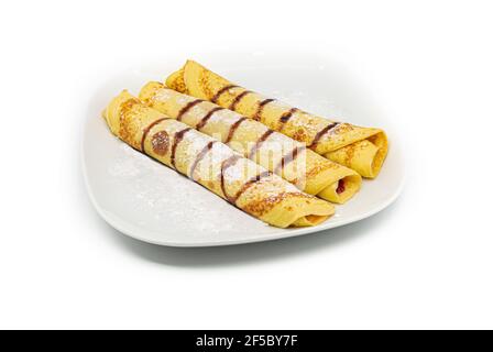 Leckere hausgemachte Crepes oder Pfannkuchen mit Waldfrucht-Marmelade oder Schokoladencreme auf weißem Hintergrund. Stockfoto