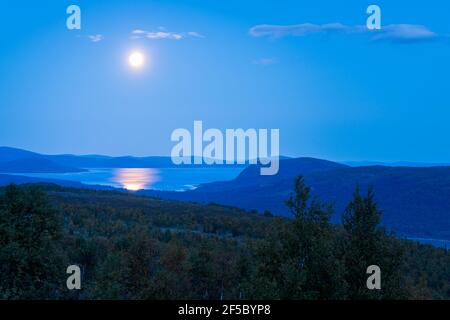 Vollmond spiegelt sich in der Wasseroberfläche des Sees tief in der schwedischen Arktis. Nacht in der abgelegenen Wildnis Lapplands. Tjaktjajajavrre See und Rapa Tal in Sarek Stockfoto