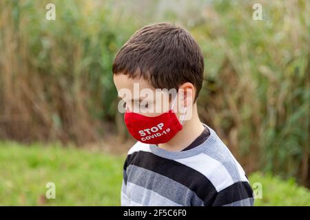 Gelangweilt und traurig Junge Kind mit Gesichtsmaske Gefühl deprimiert. Covid 19 Stockfoto