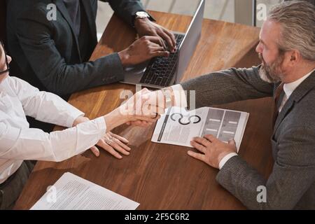 Geschäftspartner geben sich bei einem Geschäftsmeeting die Hände, das sie abschließen Ein neuer Vertrag zwischen ihnen Stockfoto