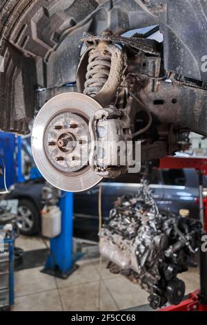 Prüft Bremsscheiben und Bremsbeläge. Auto auf einem Reparaturständer. Technische Servicestation für Auto. Stockfoto