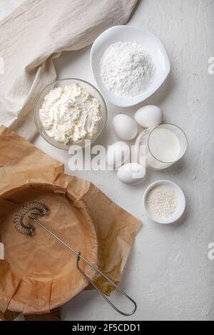 Zutaten für die Herstellung baskischen Spanisch verbrannt Saint Sebastian Käsekuchen. Frischkäse, Zucker, Eier, Mehl, Sahne, Backform mit Papier bedeckt. Recip Stockfoto