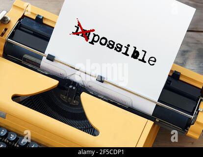 Möglich unmöglich - Wort auf Blatt Papier geschrieben auf Gelbe Schreibmaschine Stockfoto