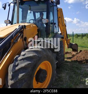 Bagger auf einer Baustelle gräbt Gräben, der Prozess der Arbeit aus nächster Nähe.neu Stockfoto