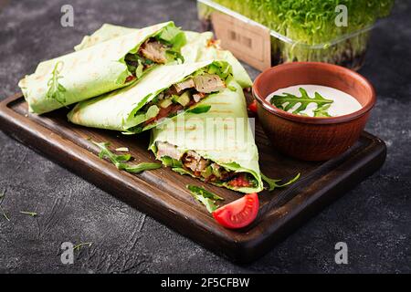 Frische Tortilla Wraps mit Huhn und frischem Gemüse auf Holzbrett. Hühnerburrito. Gesunde Ernährung Konzept. Mexikanische Küche. Stockfoto