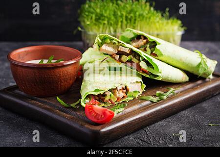 Frische Tortilla Wraps mit Huhn und frischem Gemüse auf Holzbrett. Hühnerburrito. Gesunde Ernährung Konzept. Mexikanische Küche. Stockfoto