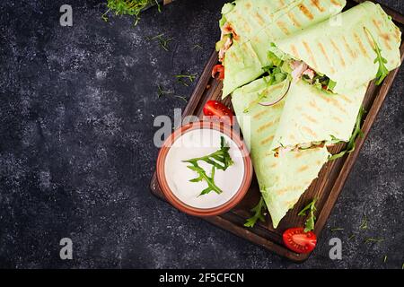 Frische Tortilla Wraps mit Huhn und frischem Gemüse auf Holzbrett. Hühnerburrito. Gesunde Ernährung Konzept. Mexikanische Küche. Draufsicht, Overhead Stockfoto