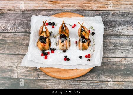 Wachtel auf einem hölzernen Hintergrund. Auf einem hölzernen Hintergrund. Little turkey. Nahaufnahme. Drei Wachteln. Kleiner Vogel. Hähnchenersatz Stockfoto