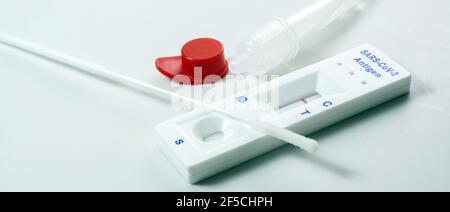 Schnellantigen-Selbsttest-Kit mit negativem Ergebnis, covid-19-Diagnose mit Nasenabstrich, Röhrchen und Detektionsgerät, hellem Hintergrund, Kopierraum, Panor Stockfoto