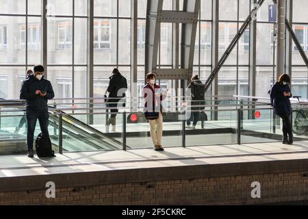 Berlin, Deutschland. März 2021, 25th. Passagiere mit Gesichtsmasken warten auf den Zug auf einem Bahnsteig eines Bahnhofs in Berlin, der Hauptstadt Deutschlands, 25. März 2021. Die täglichen COVID-19-Infektionen in Deutschland stiegen stark an, da innerhalb eines Tages 22.657 neue Fälle registriert wurden, etwa 5.100 mehr als eine Woche zuvor, sagte das Robert Koch-Institut (RKI) am Donnerstag. Die siebentägige COVID-19-Inzidenzrate des Landes stieg ebenfalls von 108,1 pro 100.000 Menschen am Vortag auf 113,3 Donnerstag, so die Bundesbehörde für Krankheitsbekämpfung und Prävention. Quelle: Stefan Zeitz/Xinhua/Alamy Live News Stockfoto