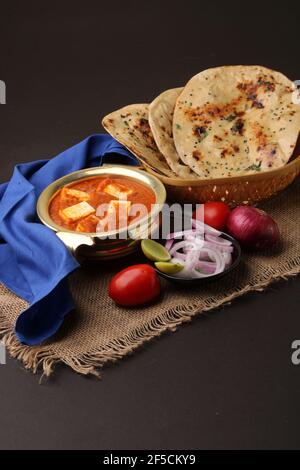 Paneer Butter Masala oder Cheese Cottage Curry in servieren eine Schüssel oder Pfanne, serviert mit Naan oder Tandoori Roti Stockfoto