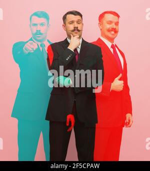 Junger Geschäftsmann in schwarzem Anzug auf rosa Hintergrund mit Glitch-Effekt. Stockfoto