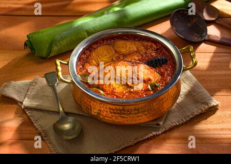 Seer Fish Curry, traditionelles indisches Fischcurry, kerala Special, arrangiert in einer Kupferschüssel garniert mit malabar Tamarinde und frischem grünem Chil Stockfoto