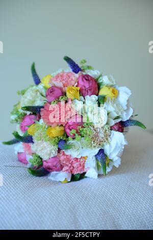 Üppiges Bouquet aus bunten Rosen gepaart mit weißen Freesias und Frühlingsgartenblumen, frisches Blumenarrangement als perfektes natürliches Accessoire geschaffen Stockfoto