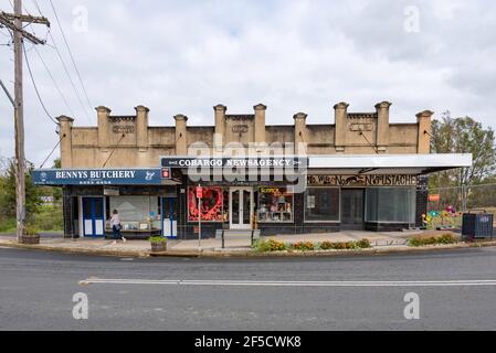 Das Benny's Building 1934 in Cobargo, New South Wales, besteht aus drei verglasten Geschäften mit Fliesenfassaden, geschwärzt von Asche aus den Buschfeuern von 2019-20 Stockfoto