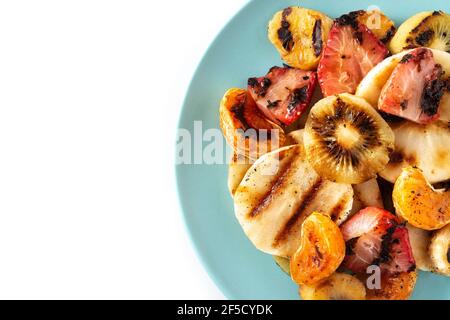 Gegrilltes Obst auf einem blauen Teller isoliert auf weißem Hintergrund Stockfoto