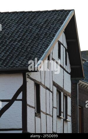 Haus mit weißen Außenwänden und Schindeln Dach Stockfoto