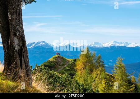 Blick über eine Hochalm im Herbst auf die schneebedeckten Gipfel der Niederen Tauern. Stockfoto