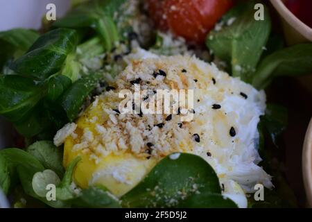 Pochiertes Ei auf Salat als Nahaufnahme Stockfoto