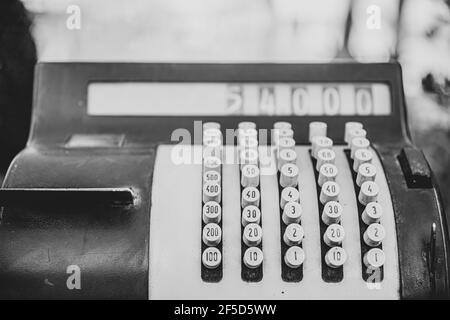 Nahaufnahme einer alten mechanischen Registrierkasse auf unscharfem Hintergrund. Stockfoto