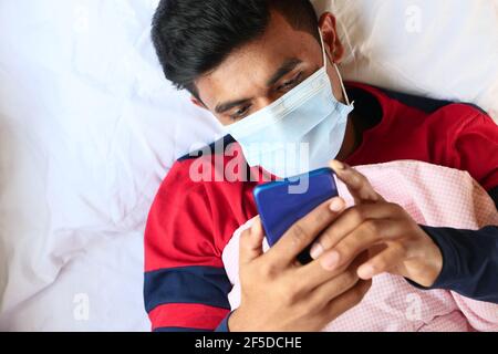 Kranker Mann in chirurgische Gesichtsmaske mit Smartphone, selektive Fokus Stockfoto