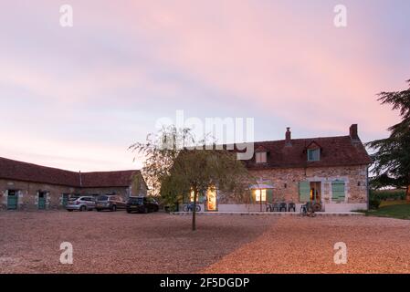 Ein rustikales französisches Bauernhaus in der Abenddämmerung. Stockfoto