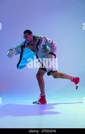 High-Fashion gestylte Mann in weißem Outfit Schnupfbox isoliert über Verlaufshintergrund in Neonlicht Stockfoto