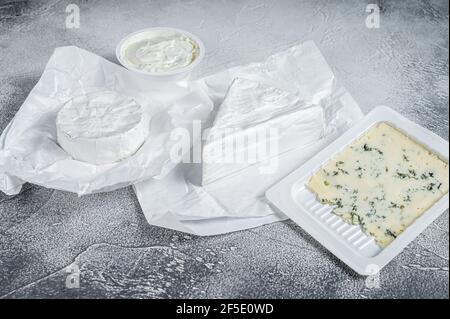 Verschiedene Käsesorten auf Küchentisch, Brie, Camembert, Gorgonzola und blauer Cremekäse. Weißer Hintergrund. Draufsicht Stockfoto