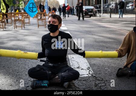 Madrid, Spanien. März 2021, 26th. Klimaaktivisten der Gruppe Extinction Rebellion (XR) ketteten sich an, die Straße vor dem Gesundheitsministerium zu blockieren, während einer Protestaktion, die Aktionen gegen den Klimawandel forderte. Quelle: Marcos del Mazo/Alamy Live News Stockfoto