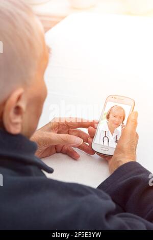 Telemedizinisches oder telemedizinisches Konzept: Leitender Patient mit Headset, der einen Videoanruf mit seinem Arzt führt. Stockfoto