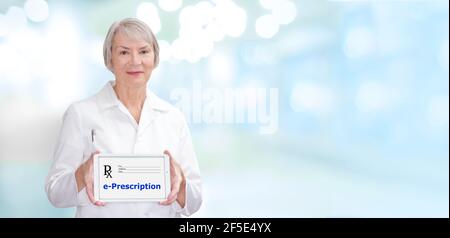 Lächelnder Apotheker zeigt einen Tablet-Computer mit dem Text: E-Prescription, also elektronische Verschreibung. Stockfoto