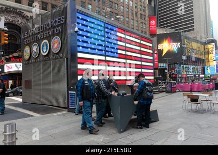 Eine Gruppe von Männern, die an einem nebligen Tag vor der Rekrutierungsstation der US-Streitkräfte auf dem Times Square in New York stehen Stockfoto