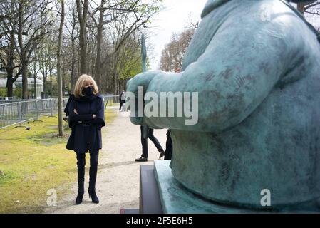 Die Ehefrau des französischen Präsidenten Brigitte Macron (R) geht mit dem belgischen Karikaturisten Philippe Geluck spazieren, während sie eine Skulptur seiner Figur aus seinem Comicstrip 'Le Chat' anschaut, die am 26. März 2021 in einer Außenausstellung auf den Champs Elysees in Paris zu sehen ist. Vom 26. März bis zum 9. Juni 2021 werden zwanzig Bronzestatuen von Gelucks Charakter aus 'Le Chat' (die Katze) ausgestellt. Foto von Eliot Blondt/ABACAPRESS.COM Stockfoto