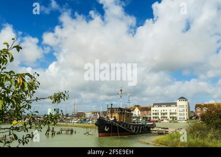 Fischerboot, das auf dem Fluss Arun mit dem Stadtzentrum von Littlehampton am Ostufer vor Anker liegt; Littlehampton, West Sussex, Großbritannien Stockfoto