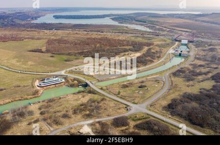 26. März 2021, Sachsen, Markkleeberg: Die Schleuse zwischen Markkleeberger See (l) und Störmthaler See ist von Hangrutschungen betroffen. Risse im Kanaldamm zwischen den Gewässern erfordern sofortige Sicherungsmaßnahmen. Der 850 Meter lange Störmthal-Kanal verbindet die beiden Seen - die betroffene Schleuse gleicht die vier Meter unterschiedliche Wasserspiegelung der beiden Gewässer aus. Experten zufolge würde ein vollständiger Einsturz zu großflächigen Überschwemmungen führen - in den nördlichen Stadtgebieten von Markkleeberg bis Leipzig. Jetzt Tauchen, Surfen, Segeln und Schwimmen sowie alle Bootfahren auf den Seen Stockfoto