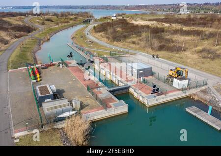 26. März 2021, Sachsen, Markkleeberg: Die Schleuse zwischen Markkleeberger See (l) und Störmthaler See ist von Hangrutschungen betroffen. Risse im Kanaldamm zwischen den Gewässern erfordern sofortige Sicherungsmaßnahmen. Der 850 Meter lange Störmthal-Kanal verbindet die beiden Seen - die betroffene Schleuse gleicht die vier Meter unterschiedliche Wasserspiegelung der beiden Gewässer aus. Experten zufolge würde ein vollständiger Einsturz zu großflächigen Überschwemmungen führen - in den nördlichen Stadtgebieten von Markkleeberg bis Leipzig. Jetzt Tauchen, Surfen, Segeln und Schwimmen sowie alle Bootfahren auf den Seen Stockfoto