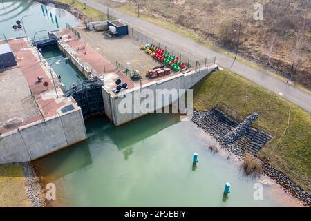 26. März 2021, Sachsen, Markkleeberg: Die Schleuse zwischen Markkleeberger See (l) und Störmthaler See ist von Hangrutschungen betroffen. Risse im Kanaldamm zwischen den Gewässern erfordern sofortige Sicherungsmaßnahmen. Der 850 Meter lange Störmthal-Kanal verbindet die beiden Seen - die betroffene Schleuse gleicht die vier Meter unterschiedliche Wasserspiegelung der beiden Gewässer aus. Experten zufolge würde ein vollständiger Einsturz zu großflächigen Überschwemmungen führen - in den nördlichen Stadtgebieten von Markkleeberg bis Leipzig. Jetzt Tauchen, Surfen, Segeln und Schwimmen sowie alle Bootfahren auf den Seen Stockfoto