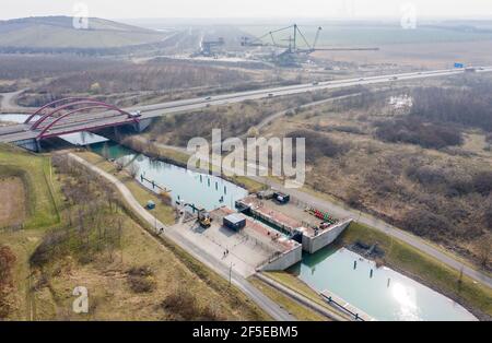 26. März 2021, Sachsen, Markkleeberg: Die Schleuse zwischen Markkleeberger See (r) und Störmthaler See ist von Hangrutschungen betroffen. Risse im Kanaldamm zwischen den Gewässern erfordern sofortige Sicherungsmaßnahmen. Der 850 Meter lange Störmthal-Kanal verbindet die beiden Seen - die betroffene Schleuse gleicht die vier Meter unterschiedliche Wasserspiegelung der beiden Gewässer aus. Experten zufolge würde ein vollständiger Einsturz zu großflächigen Überschwemmungen führen - in den nördlichen Stadtgebieten von Markkleeberg bis Leipzig. Jetzt Tauchen, Surfen, Segeln und Schwimmen sowie alle Bootfahren auf den Seen Stockfoto