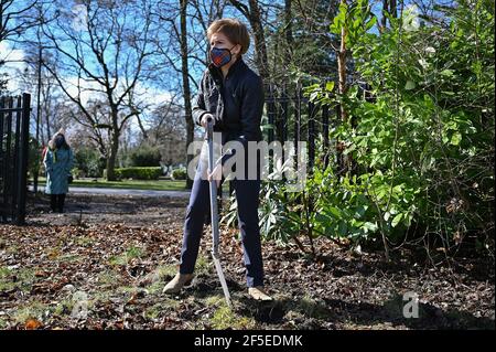 Erste Ministerin, Nicola Sturgeon, Vorsitzende der Scottish National Party, pflanzt Blumen in einem Gemeinschaftsgarten im Overtoun Park, Rutherglen, South Lanarkshire, während sie sich für die schottischen Parlamentswahlen einsetzt. Bilddatum: Freitag, 26. März 2021. Stockfoto