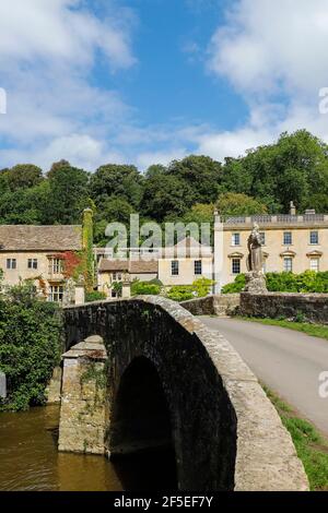 Brücke über den Fluss Frome und die klassische georgianische Südwestfassade von Iford Manor & Gardens aus den 1730er Jahren; Iford Bradford-on-Avon, Wiltshire, Großbritannien Stockfoto