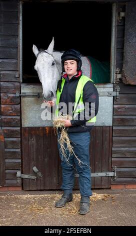 Grand National Gewinner Neptune Collonge mit seinem Trainingsreiter Billy Page in den Paul Nicholls Stables in Ditcheat, Somerset. Stockfoto