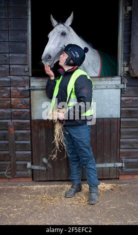 Grand National Gewinner Neptune Collonge mit seinem Trainingsreiter Billy Page in den Paul Nicholls Stables in Ditcheat, Somerset. Stockfoto