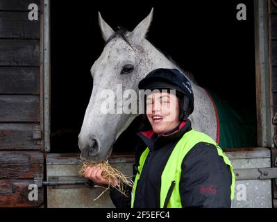 Grand National Gewinner Neptune Collonge mit seinem Trainingsreiter Billy Page in den Paul Nicholls Stables in Ditcheat, Somerset. Stockfoto